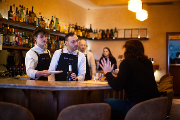 Two busy bartenders work in tandem behind the bar.