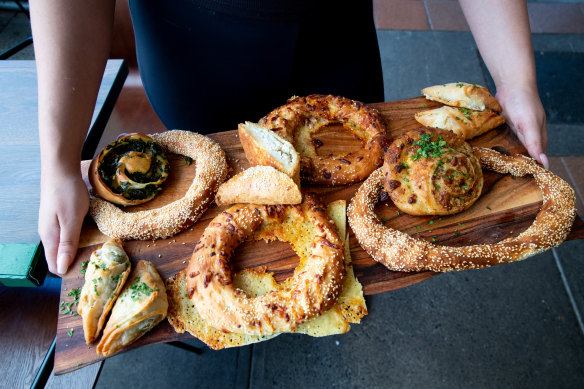 A mixed tray of pastries including the round sesame-seed-studded koulouri.