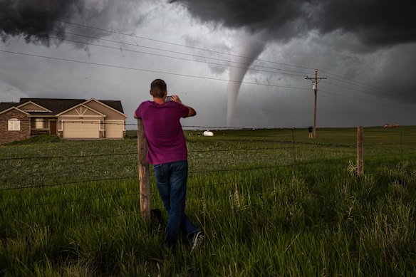 A local resident of Cheyanne, Wyoming watches one of several destructive tornadoes wander through the nigh plains where they damaged and destroyed several homes, 2018.  
