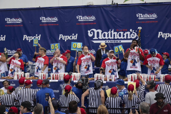 Competitive eaters eat hot dogs during the 2023 Nathan’s Famous Fourth of July hot dog eating contest.