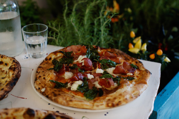 La mucca pizza with white base pizza, fior di latte, rocket,burrata, bresaola, balsamic glaze and black pepper.