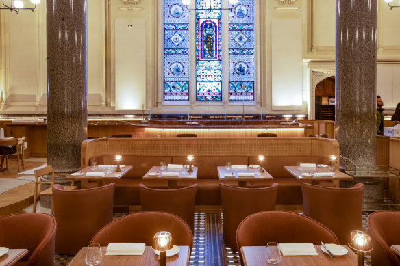 Tan leather and perforated timber booths help divide the grand dining room.