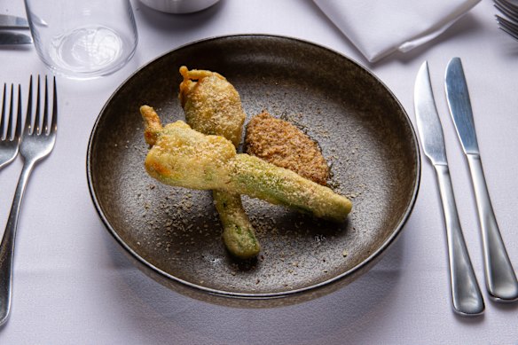 Mozzarella-stuffed fried zucchini flowers with smoked almond.
