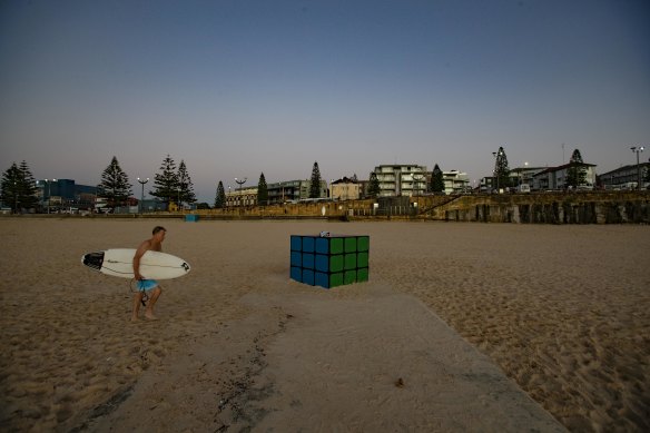Beachgoers are seen near the Maroubra Rubik’s Cube at sunrise on Friday.