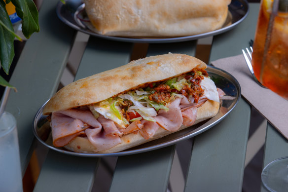 Muffaletta sandwich with Italian sliced meats, tomatoes and olives.