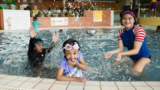 Aiden and Hermione Kumar and Sophia Acosta play after their swimming lessons at Blacktown Leisure Centre.