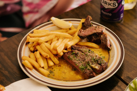Steak with “umami butter” is cooked over a wood grill.