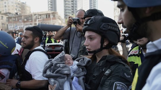 A baby is carried away from the site of an Iranian missile attack in Israel.