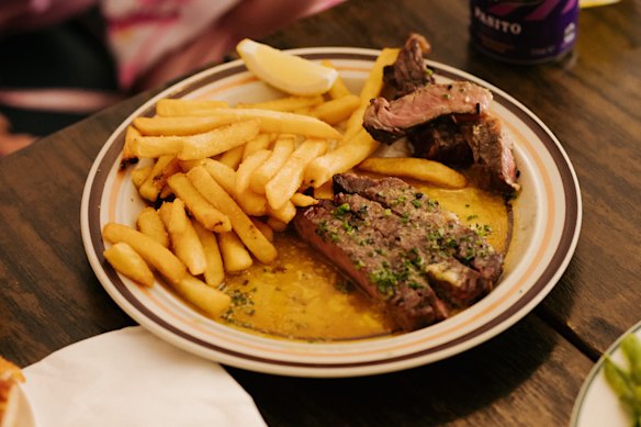 Steak with “umami butter” is cooked over a wood grill.