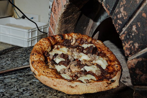 The salsiccia pizza is topped with sausage and porcini mushrooms.    