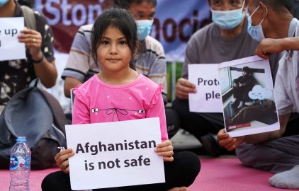 Afghan refugees gather outside the UNHCR office in Jakarta on Tuesday after a deadly bomb blast in Kabul. 