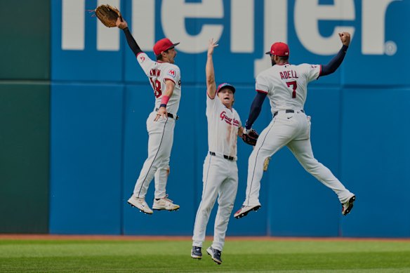 Cleveland Guardians left fielder Steven Kwan, left, center fielder Petey Halpin, center, and right fielder Jo Adell (7) celebrate after the Guardians defeated the Chicago White Sox in a baseball game in Cleveland.