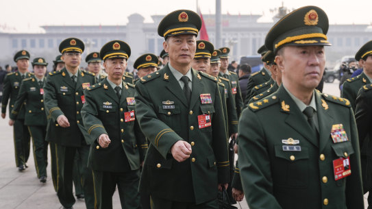 Military delegates march ahead of the opening session of the National People’s Congress at the Great Hall of the People in Beijing.