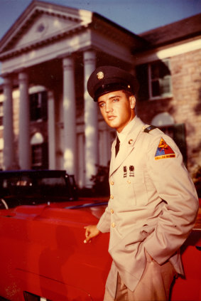 Elvis Presley in an army uniform outside Graceland.