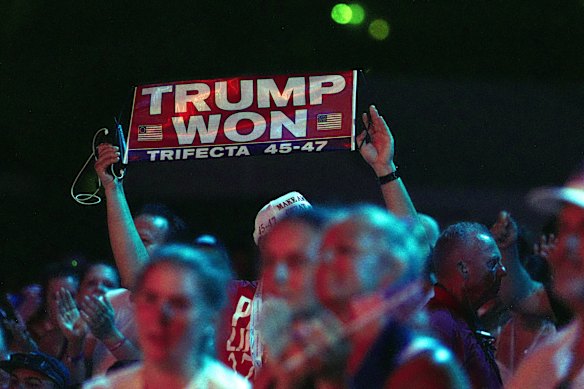 An attendee shows a “Trump won” sign in the crowd.