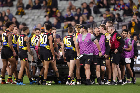 Richmond players gather around Sam Banks before he was driven off the ground.