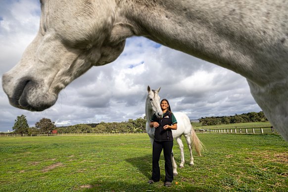 Molly Stewart and Chautauqua pose for a picture under the neck of Fawkner.