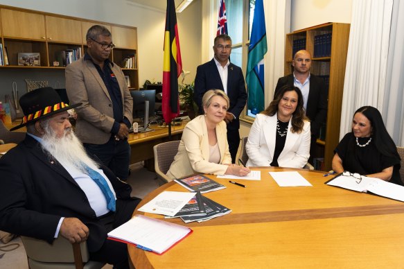 Environment Minister Tanya Plibersek signs an agreement to co-deign new laws. Pictured with Patrick Dodson, Dr Heron Loban and Linda Burney (sitting) and Anthony Watson, Paul House and Jamie Lowe (standing).