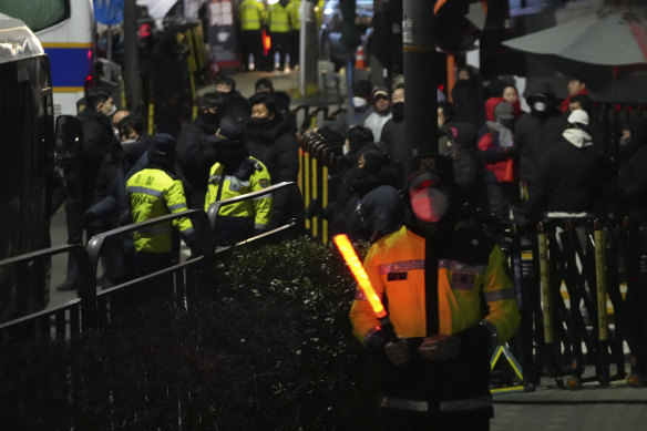 Police officers stand in front of the gate of the presidential residence of impeached South Korean President Yoon Suk Yeol in Seoul, South Korea, in the early hours of Wednesday.