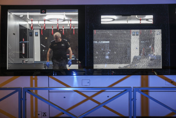 An Israeli forensic officer examines a light rail car following a shooting attack.