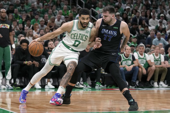 Boston Celtics forward Jayson Tatum (0) drives toward the basket as Dallas Mavericks guard Luka Doncic (77).