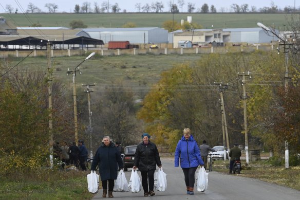 Locals carry bags of food distributed by World Kitchen near Kherson.