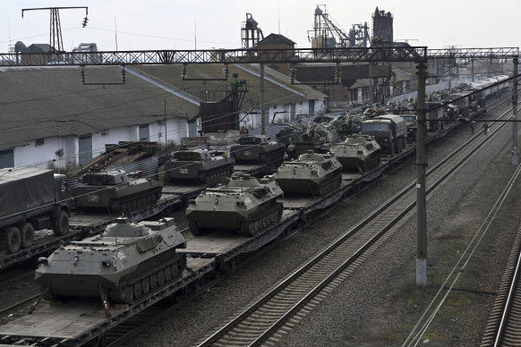 Russian armored vehicles are loaded onto railway platforms at a railway station in region not far from Russia-Ukraine border on February 23.