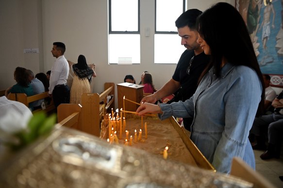Palestinian Christians kissed the holy gospel as they walked into the Saints Peter and Paul Antiochian Orthodox Church in Doonside for a Christmas Day service. Some also lit candles.