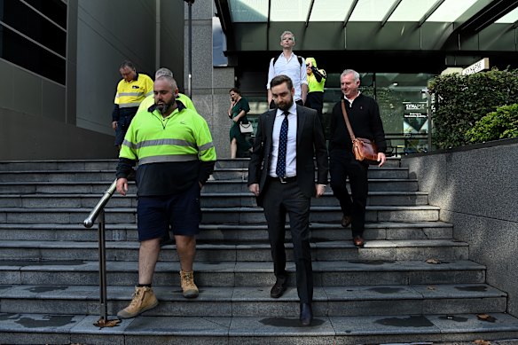 Liverpool council employees and United Services Union lawyer Joel Tucker leave the Industrial Relations Commission in Parramatta.