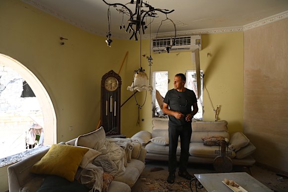 A man stretches in his house that has been struck by an ironian missile shot in the northern Island city of Tamra 15th June.