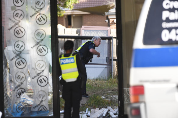 Police officers search a property near the crime scene in Endeavour Hills on Tuesday. 