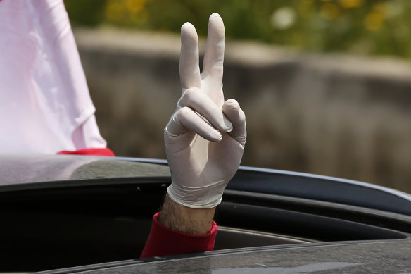 An anti-government protester flashes victory sign from the sunroof of his car in Beirut. 