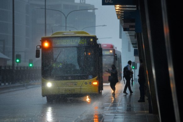 Drenched: Commuters wait for buses at Parramatta Station on Tuesday.