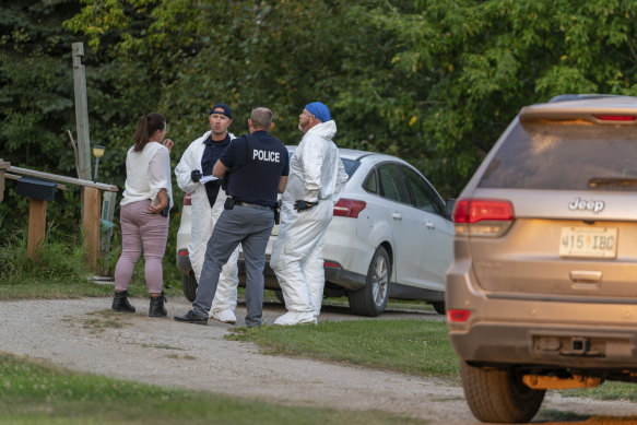 Investigators gather in front of a crime scene in Weldon, Saskatchewan.