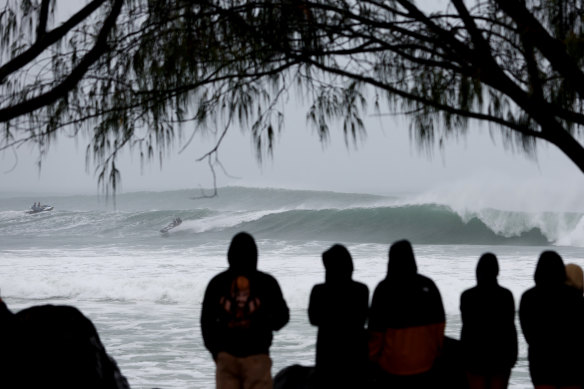 People watch jet skis and surfers at Kirra Beach on Wednesday ahead of Cyclone Alfred.