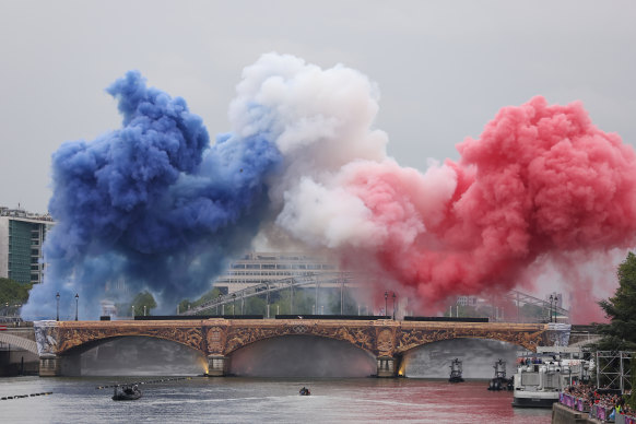 Smoke resembling the flag of Team France is shown over Pont d’Austerlitz during the opening ceremony of the Olympic Games.