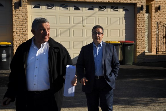 Shaoquett Moselmane, right, with his lawyer as he leaves his home on Lennox Street in Rockdale during a raid by federal agents.