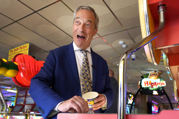 Nigel Farage plays on a game in an amusement arcade while spending time with supporters in Clacton-on-Sea.