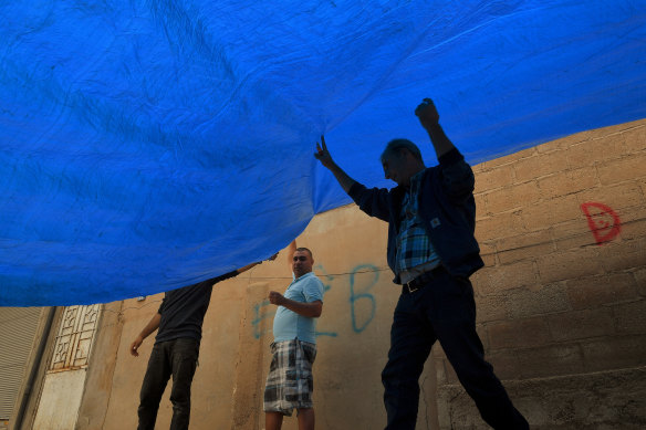 Civilians in the border town of Darbasiyah erect tarpaulins in the streets to hide their movements.