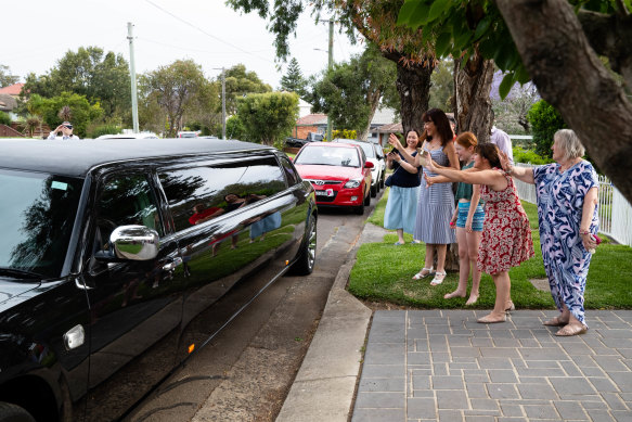 Parents of the Our Lady of Mercy College Parramatta group wave goodbye to their daughters as they depart for the formal in a limousine.