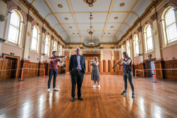 The Academy’s Nick Bailey inside the South Melbourne Town Hall with musicians Jamie Miles, Isabella Thomas and Alexandra King.
