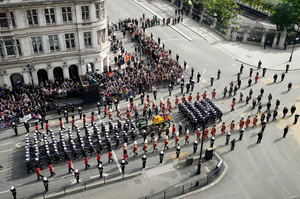 The State Gun Carriage carries the coffin of Queen Elizabeth II, draped in the Royal Standard with the Imperial State Crown.