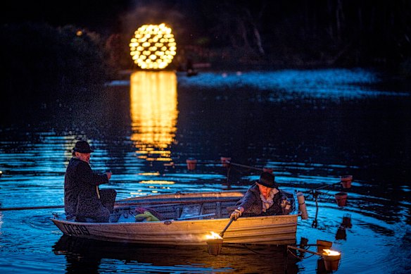 Staff at Compagnie Carabosse light floating fire pots from a paddle boat.