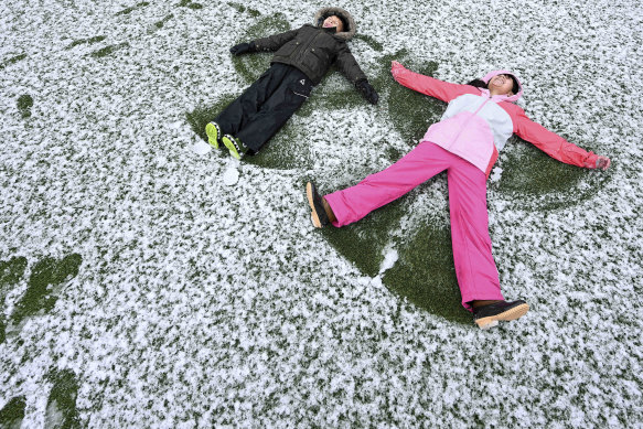 Jacob Polanco (a sinistra), 8 anni, e sua sorella maggiore Chloe, 9 anni, fanno angeli di neve dopo una nevicata nel loro cortile di 1.400 piedi a Rancho Cucamonga, in California, sabato.