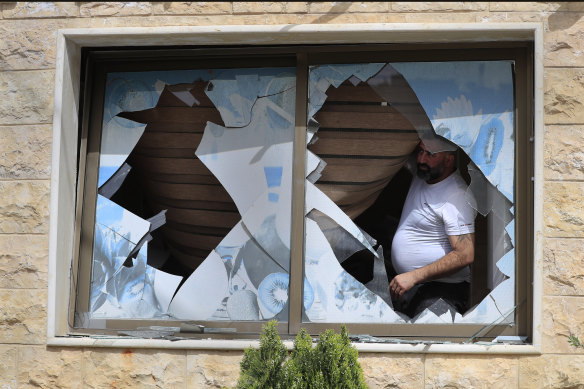 A Lebanese villager looks through a broken window of his house damaged by Israeli shelling in Kfar Kila, a border village with Israel, last week.