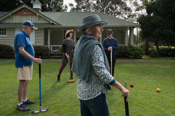 Robyn Weihen (front) plays with (from left) Rod Richardson, Heritage NSW manager of incentives engagement Lana Zegura and senior heritage officer Stuart Read at Sydney Croquet Clubhouse at Rose Bay.