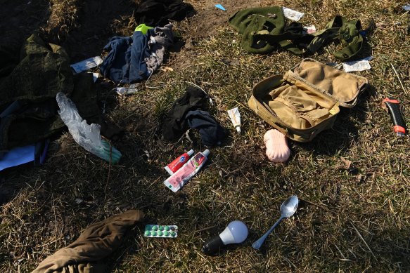 The possessions of Russian soldiers are scattered across the ground near an armoured vehicle after a battle killed six Russian soldiers.