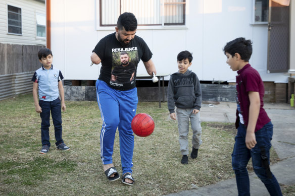 'It's hard to balance': Ghanim al-Shnen plays football with his sons, who will soon return to their home in Finland. 