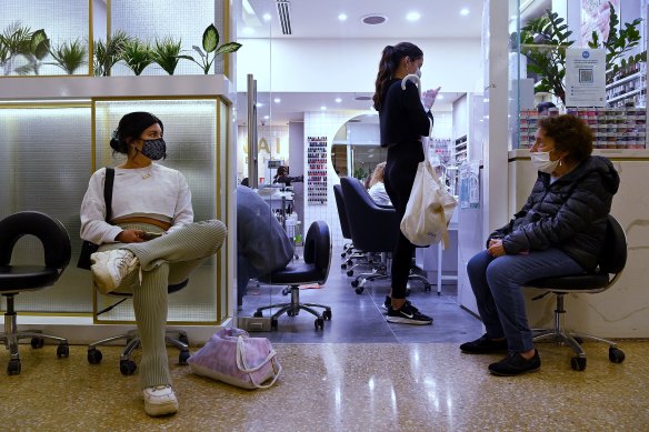 Pauline Pinete (left) waits to enter a nail salon in Westfield Bondi Junction shopping centre on the first day of relaxed COVID-19 restrictions 
