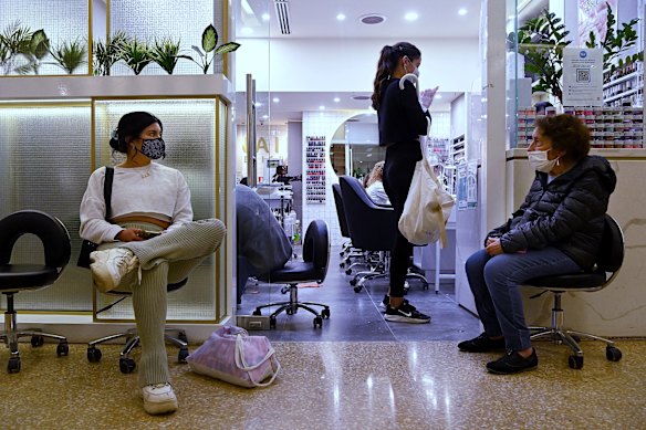 Pauline Pinete (left) waits to enter a nail salon in Westfield Bondi Junction shopping centre on the first day of relaxed COVID-19 restrictions 